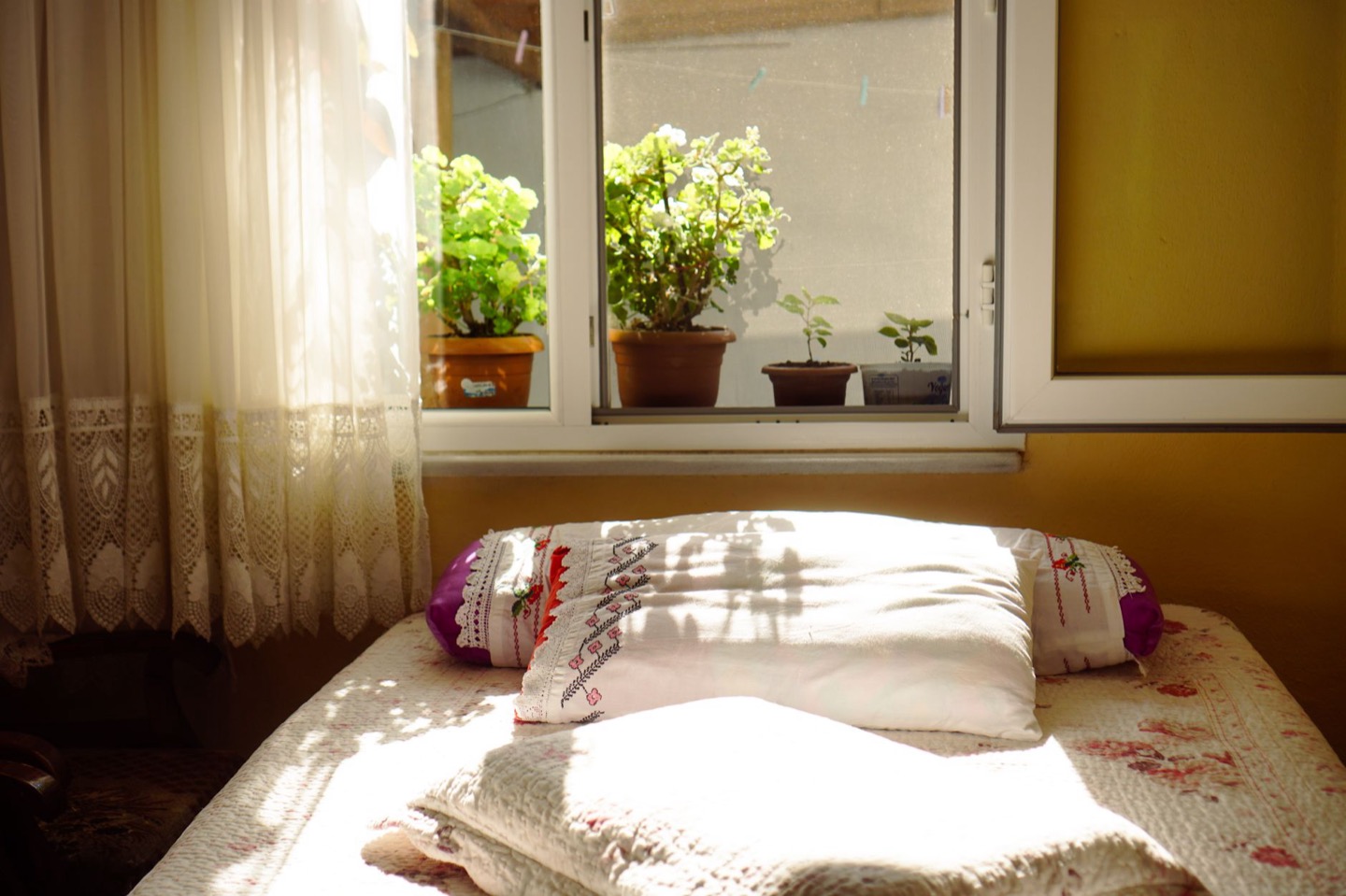 Airbnb bedroom before and after adding layered blackout window treatments — before