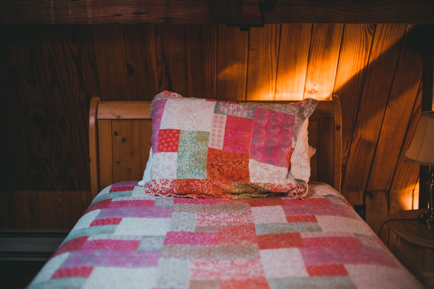 Airbnb bed before and after switching to white bedding with colored layers — before